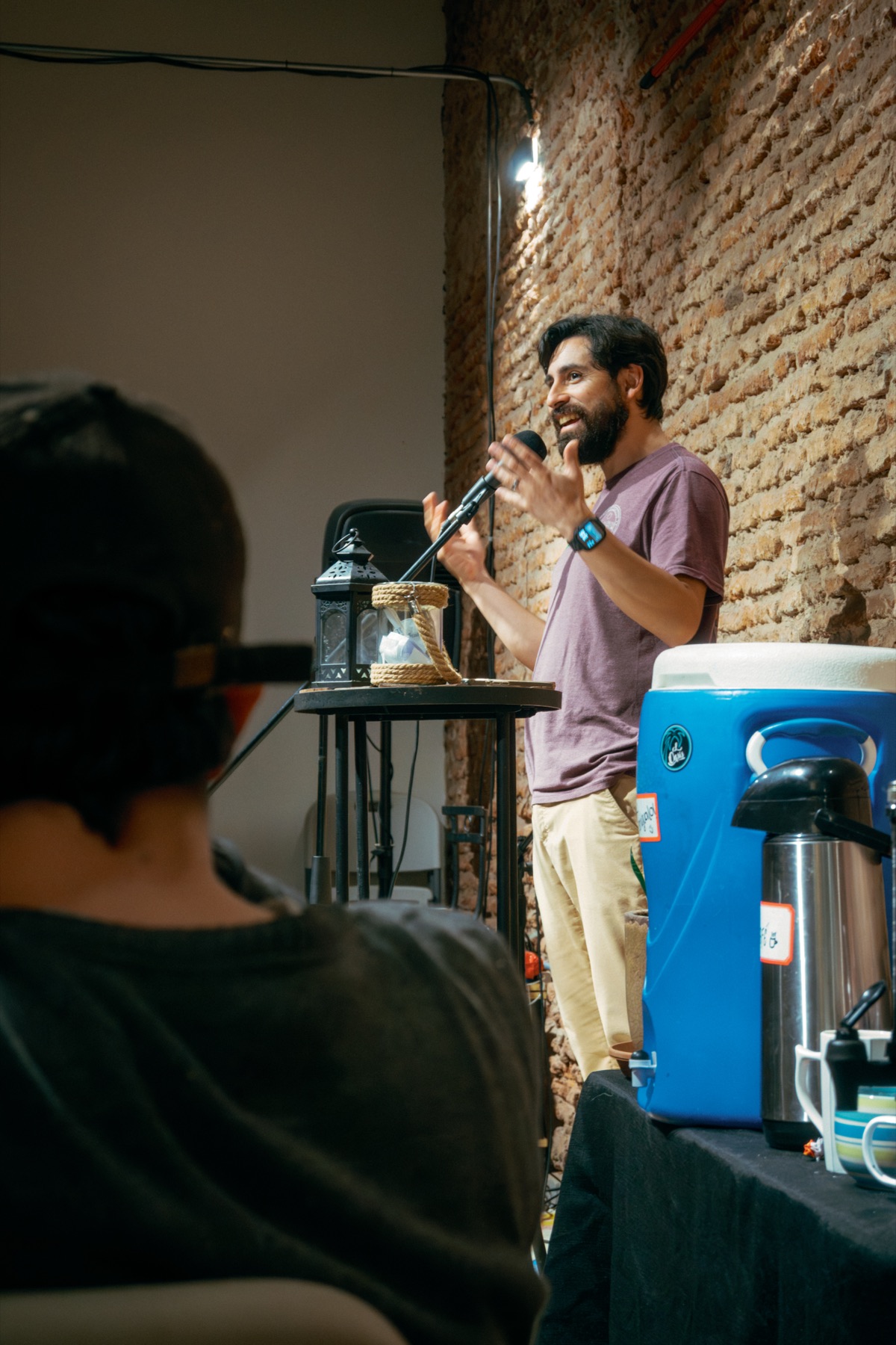 Un chico hablando con micrófono en un Open Mic en la casa
